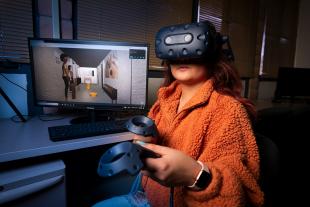 Cal Poly computer science major Zahnae Aquino uses an HTC VIVE headset and controllers to navigate a virtual reality environment that she created with fellow student Josie Grundler.